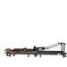 Space-saving Pilates reformer folded upright with wheels and locking system