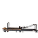 Space-saving Pilates reformer folded upright with wheels and locking system