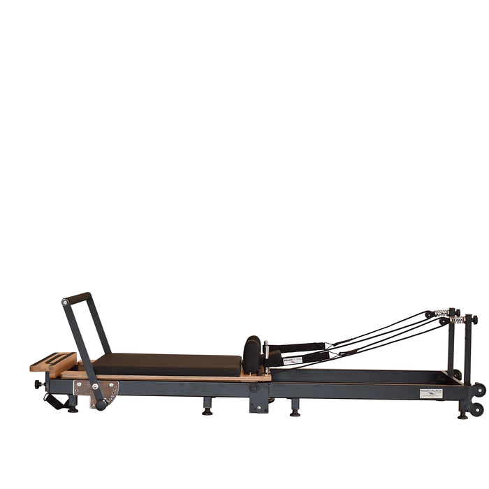 Space-saving Pilates reformer folded upright with wheels and locking system