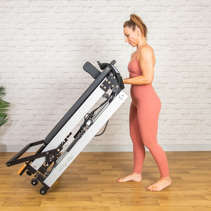 Woman wheeling Align-Pilates F3 Folding Pilates Reformer