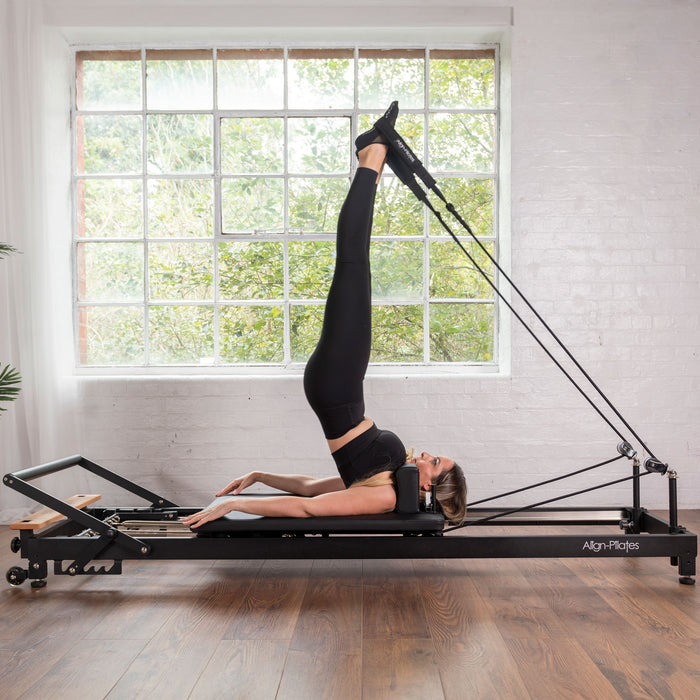 Woman Exercising on Align-Pilates R8-Pro Pilates Reformer Black