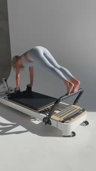 The Core Collab Queen 2.0 Studio Pilates Reformer - side view showing rail system and adjustable footbar