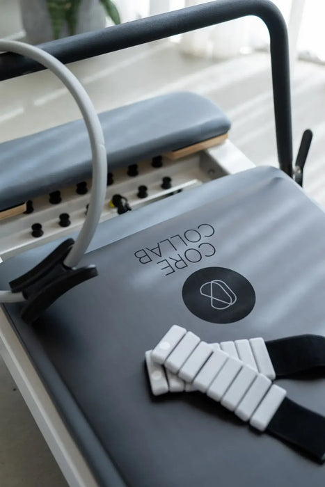 TCC Queen Foldable Pilates Reformer - close-up of padded carriage and shoulder rest pad system