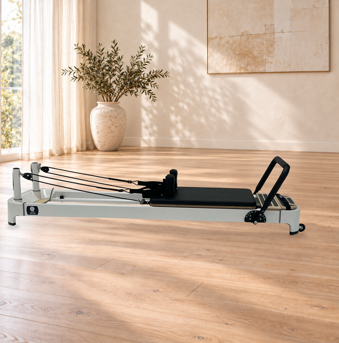 Core Collab Queen 2.0 Black reformer, original supplier product photograph composited onto an AI-generated room background