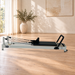 Core Collab Queen 2.0 Black reformer, original supplier product photograph composited onto an AI-generated room background
